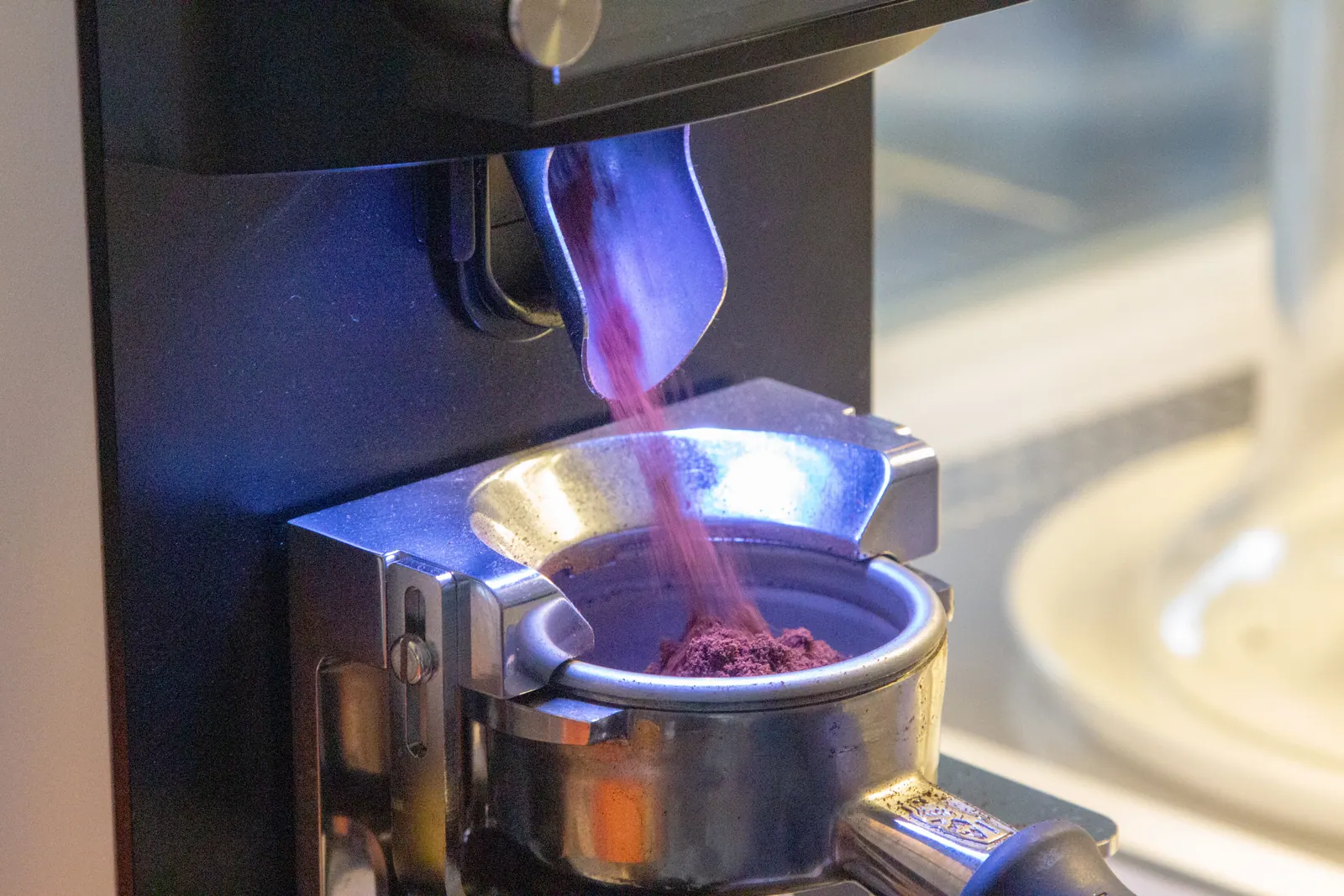 Espresso değirmeninden portafiltreye akan taze öğütülmüş kahve