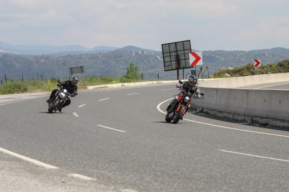 Tepelerin önünde virajı birlikte alan iki motosiklet